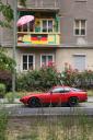 Немецкая идилия: балкон в цветах с флагом и порш под ним